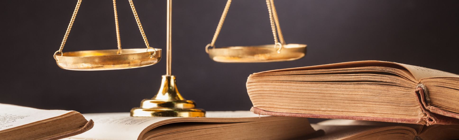 Balanza de la justicia encima de unos libros antiguos